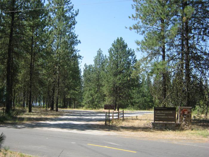 Parking with pine trees and the lake in the backgroundOpen site with partial shade