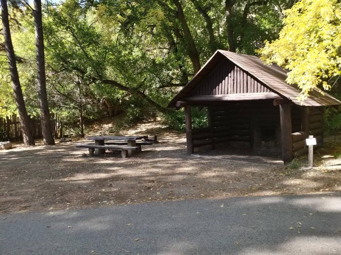Site 3 with a picnic table, shelter unit, fire ring, and parking.
