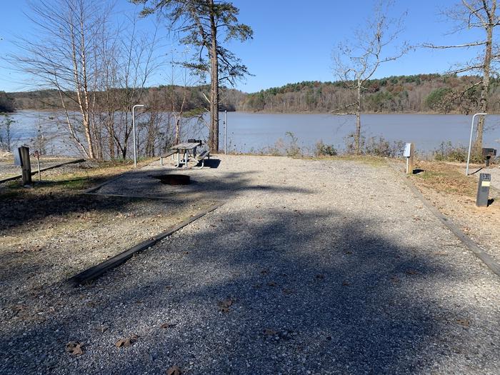 Gravel pull in to site with fire pit, table, grill, and lakefront views 