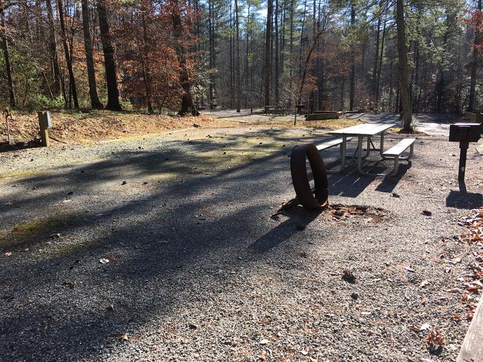 Gravel site with fire pit, grill, table 