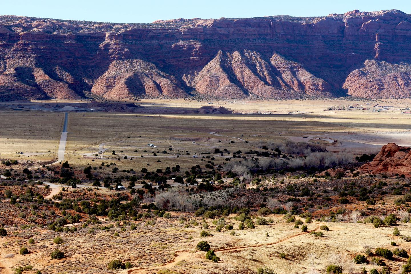 Overview of Ken's Lake Campground with desert cliffs in the background.