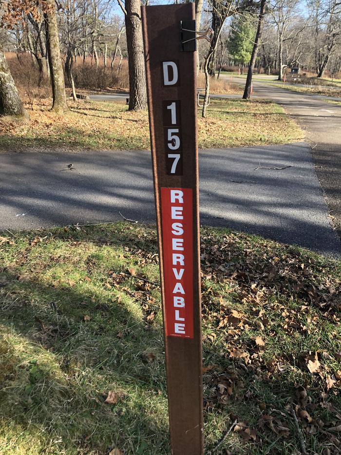 D157 sit marker; If you reserve this site, your camping pass will be attached to this marker.  When you check out, drop your pass at the registration office.If you reserve this site, your camping pass will be attached to this marker.  When you check out, drop your pass at the registration office.