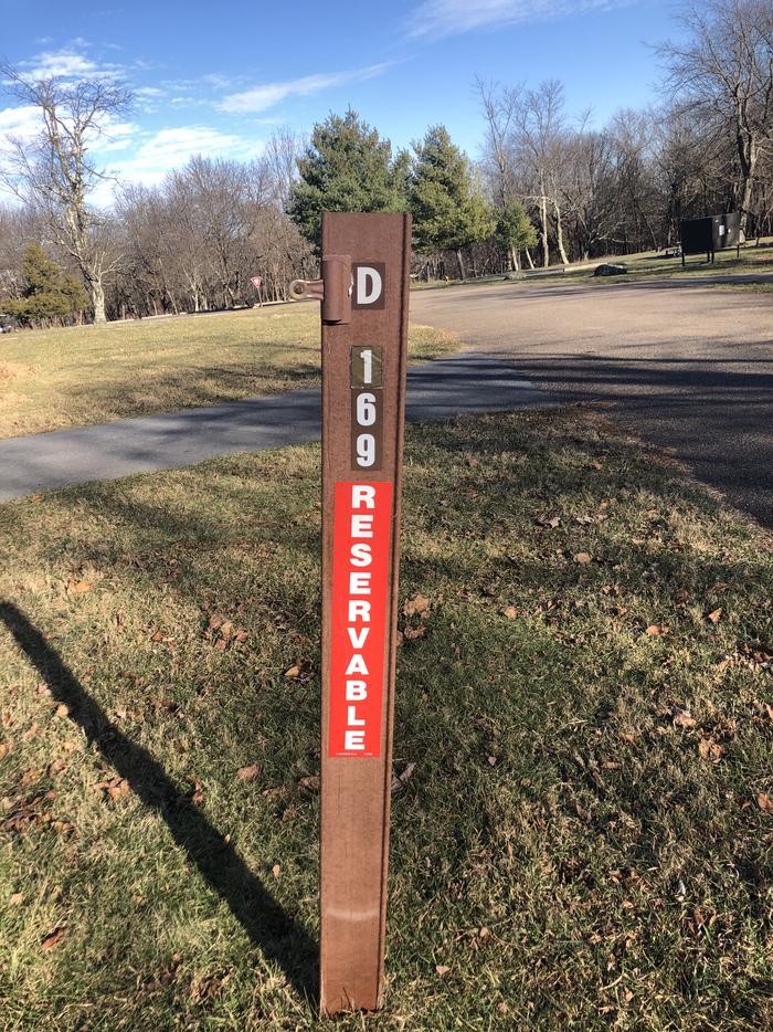D169 site marker; If you reserve this site, your camping pass will be attached to this marker.  When you check out, drop your pass at the registration office.