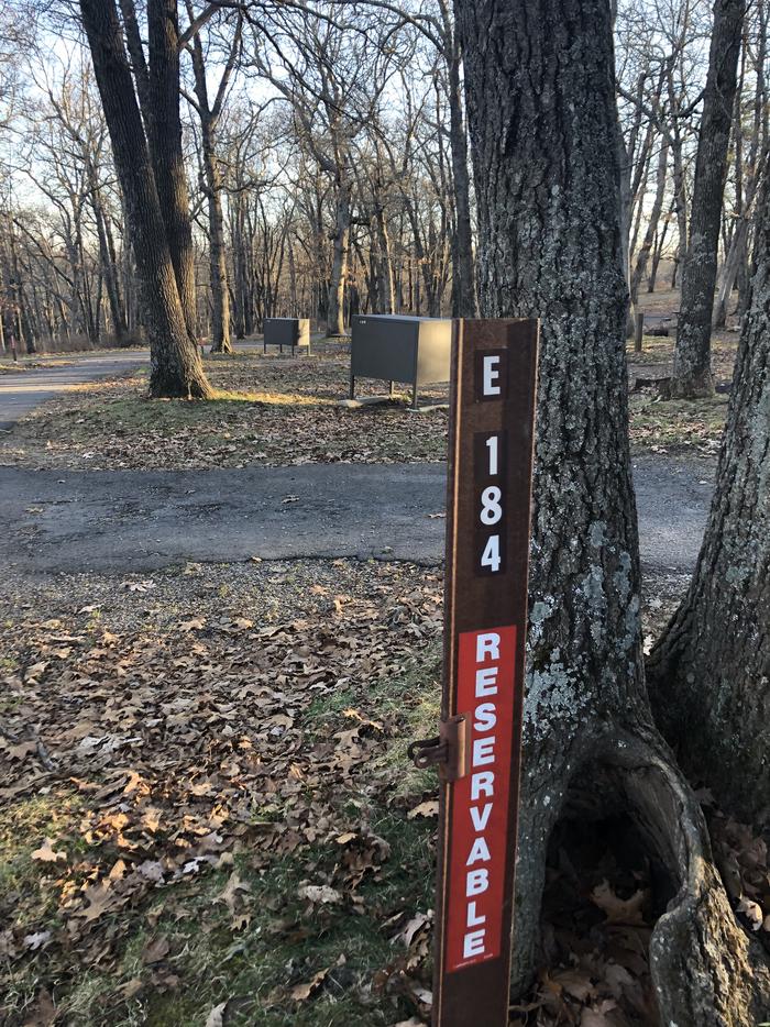 Site marker for Campsite E184; If you reserve this site, your camping pass will be attached to this maker.  When you check out drop your camping pass at the registration office.