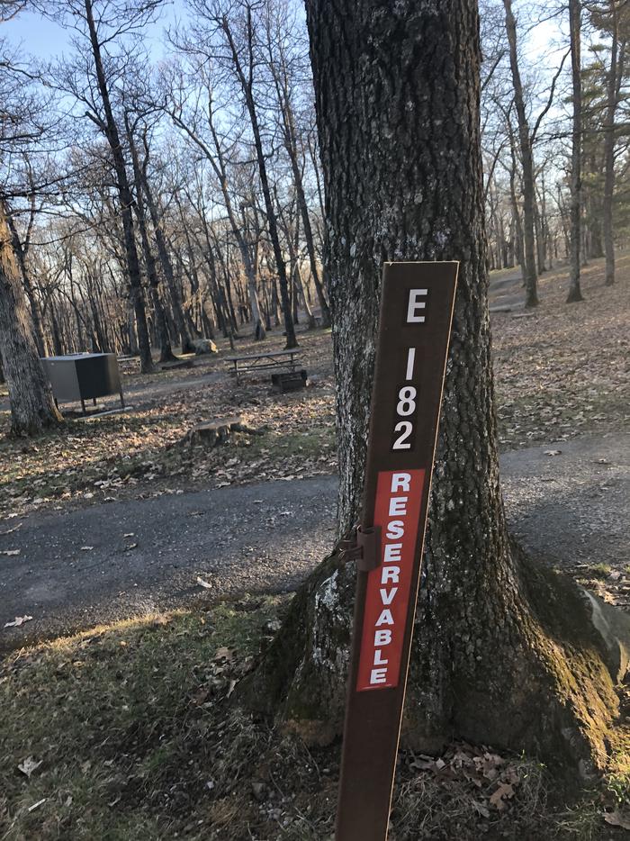 Site marker for Campsite E182; If you reserve this site, your camping pass will be attached to this maker.  When you check out drop your camping pass at the registration office.