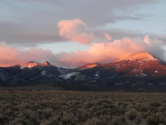 Snowy mountain peaks glowing with sunrise colorsSnake Range sunrise