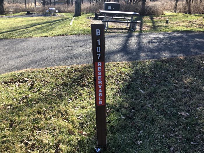 Site marker for B107; If you reserve this site, your camping pass will be attached to this site marker.  When you check out, drop your pass off at the registration office. If you reserve this site, your camping pass will be attached to this site marker.  When you check out, drop your pass off at the registration office. 