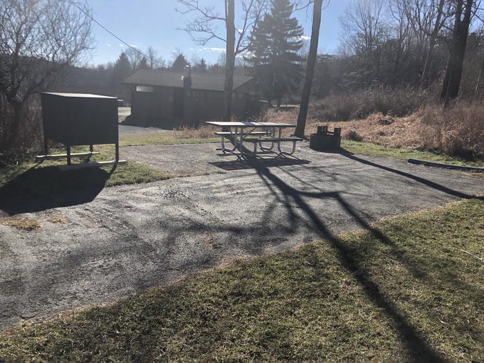 Site B111Accessible campsite has a driveway, tent pad, extended picnic table, raised fire pit, and food storage box. 