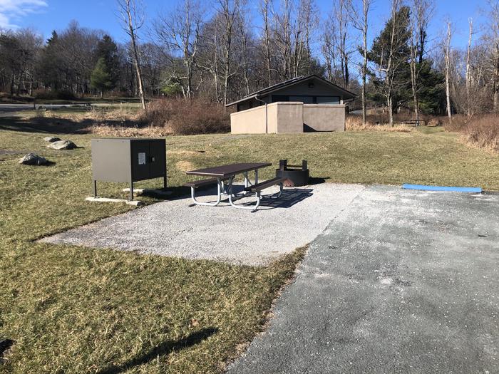 Standard ADA Accessible site A63Accessible campsite has a driveway, tent pad, extended picnic table, raised fire pit, and food storage box. 