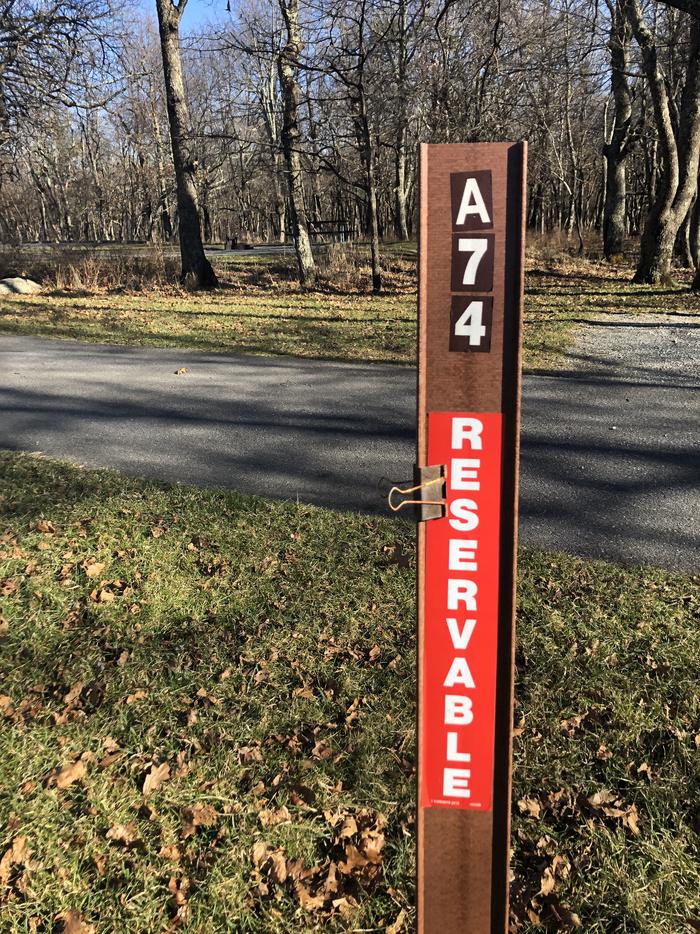 Site marker for A74; If you reserve this site, your camping pass will be attached to this site marker.  When you check out, drop your pass off at the registration office. If you reserve this site, your camping pass will be attached to this marker.  When you check out drop your camping pass off at the registration office.