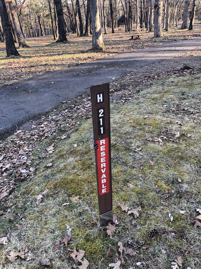 Site marker for campsite H211; If you reserve this site, your camping pass will be attached to this maker.  When you check out drop your camping pass at the registration office.