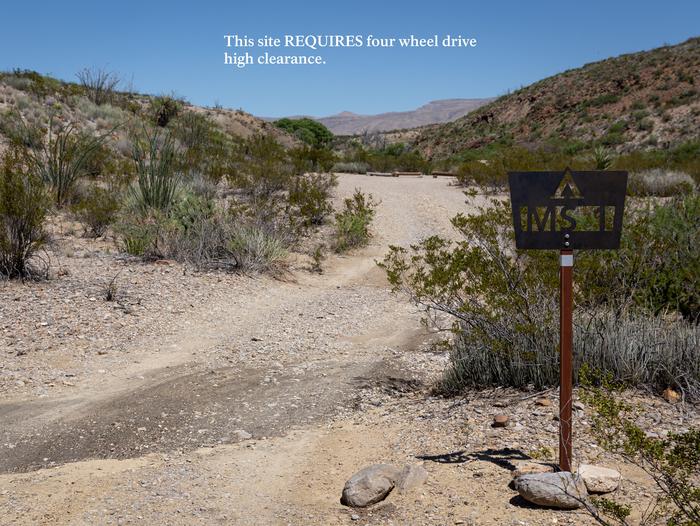 Nestled desert area with campsite markerAccess and campsite marker, with warning: "This site requires four wheel drive and high clearance".
