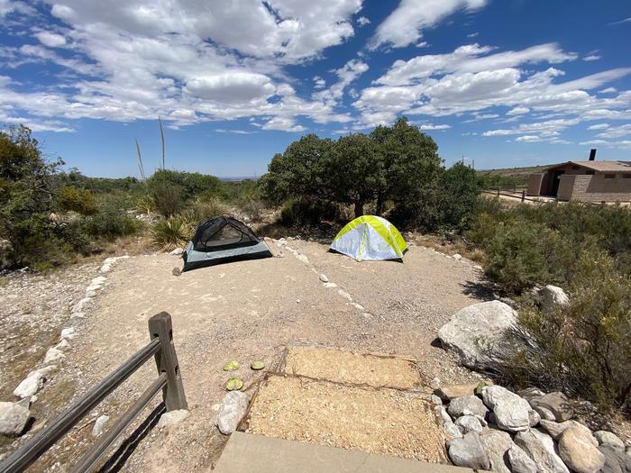Two additional tent pads located on group site #1, displaying two person tents on each pad.  Desert vegetation surrounds the area.  An accessible vault toilet is a short distance from this group site and can be seen to the right side of these tent pads.Two additional tent pads located on group site #1, displaying a two person tents on each pad.  Desert vegetation surrounds the area.