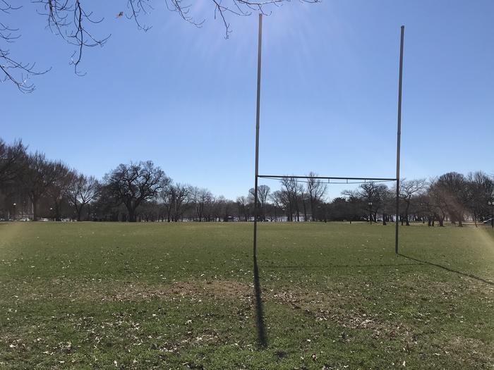 A view of the Raoul Wallenberg Mixed Use Field featuring a grassy area, goal posts, scattered trees, and the Tidal Basin in the background.Raoul Wallenberg Mixed Use Field