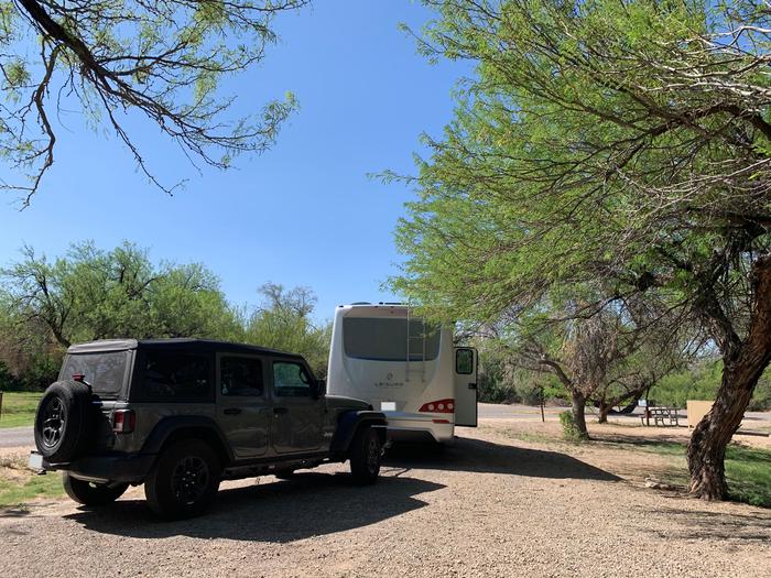 Back-end view of the pull through driveway. Campers have parked a class b RV and Jeep in the space, but a large tree with low hanging branches poses a considerable challenge for large vehicles. This camper has parked far to one side of the space to avoid some of the branches.View of the pull-through driveway for Site 45