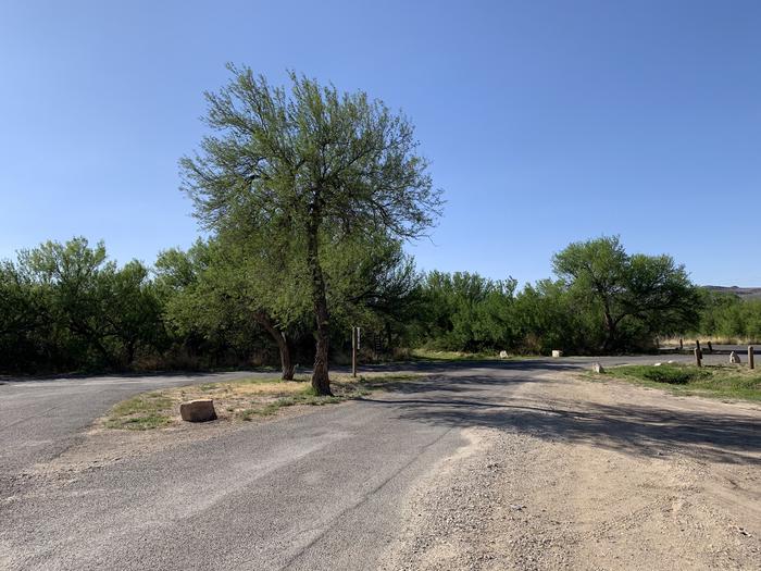 View of the pull-through driveway leading from the main road. The parking space offers plenty of room for large vehicles and RVs, and connects back to main road near the campground entrance.View of the pull-through driveway and campsite, near the entrance to the campground