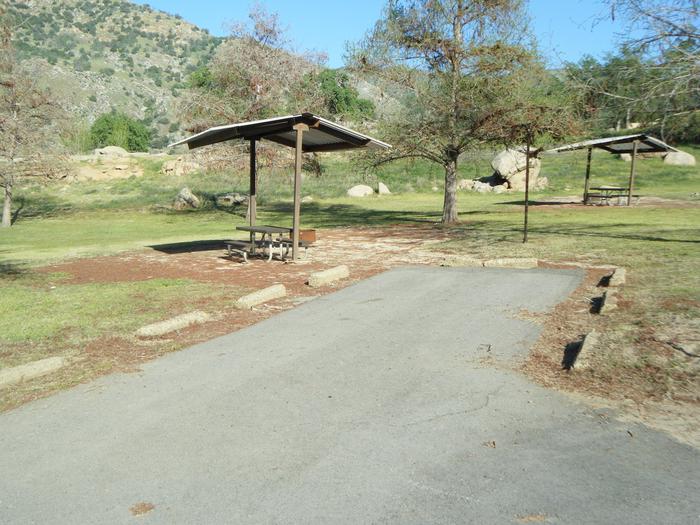 Campsite pad has shade cover over table. small tents (4 max.) or family tent for 8. Spring photo of the site. Limited shade over table. 2 unit back in driveway. 