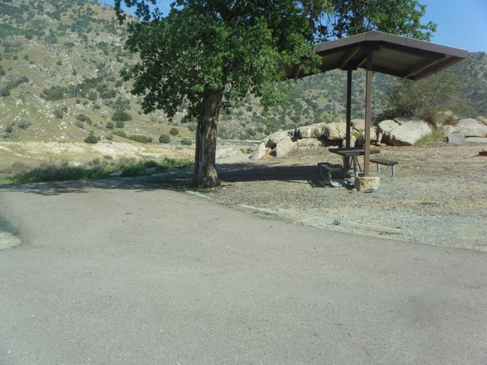 Small campsite with a small parking pad. Parking pad entrance shared with campsite 78. Parking pad for one unit or two very small . The site has a the shade cover over the table, campfire ring, and one oak tree near the parking pad. Room for two small backpack tents or one family tent for 8. 
