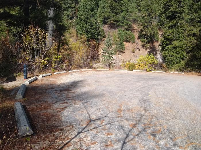 A round paved parking lot surrounded by trees.Group parking at Hayfork Campground.