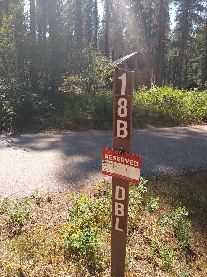 A sign saying "18B DBL Site" in front of a paved driveway.Site 18B is a a double site with a paved driveway.
