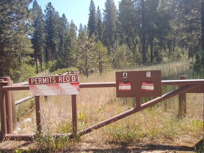A gate with signs reading "Permits Required" for Grayback Group Sites A and B.The gate to Grayback Group A and B campsites.