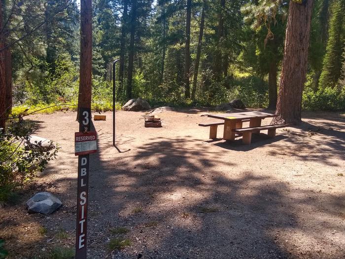 A campsite with a sign that says, "3 DBL SITE" with a picnic table, fire ring, and lantern hook.Bad Bear Site 3 is a double site.