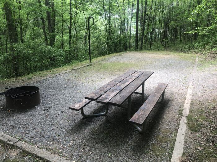 Large flat dining area and tent pad with lake access trail