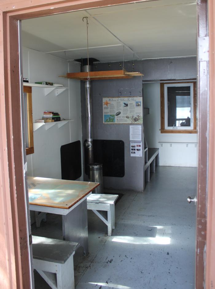 view of cabin inside showing table and stoveBlue Fox Bay Cabin Inside