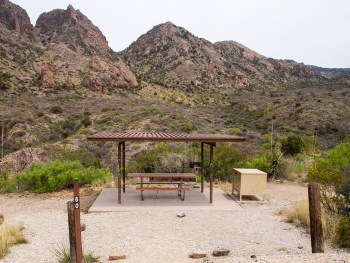 Mountains surround this campground and site. Flat site, situated downslope of the road. Mountains surround this campground and site. Shade shelter provides added sun protection.