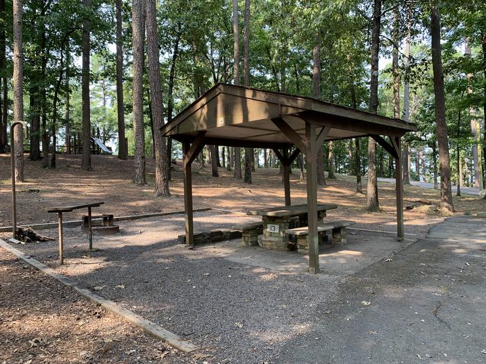 Close up of table area.A photo of Site 13 of Loop QCOV at QUARRY COVE with Picnic Table, Electricity Hookup, Fire Pit, Shade, Lantern Pole, Water Hookup