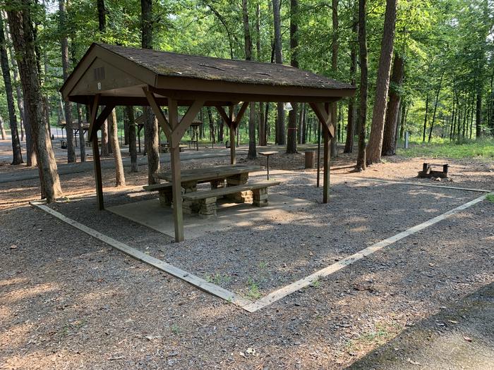Close up of table area.A photo of Site 18 of Loop QCOV at QUARRY COVE with Picnic Table, Electricity Hookup, Fire Pit, Shade, Lantern Pole, Water Hookup