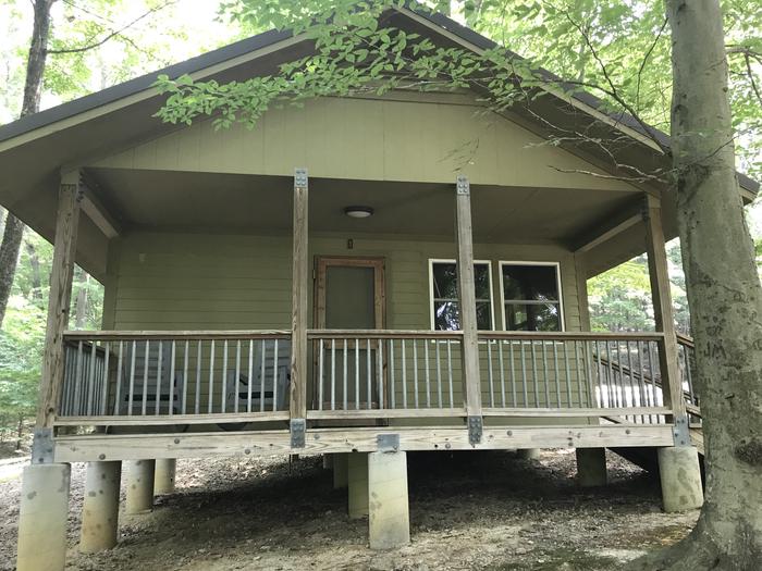 Shot from the front of the cabin looking out towards the lake with two rocking chairs on the deck for your relaxing comfort