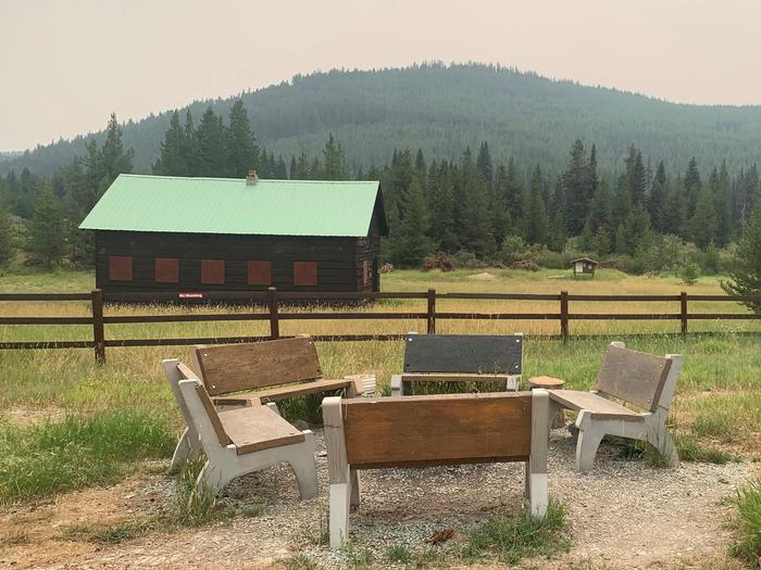 Five benches around a campfireBack yard fire pit with benches. Historic barn and NFST 171A trailhead in background. 