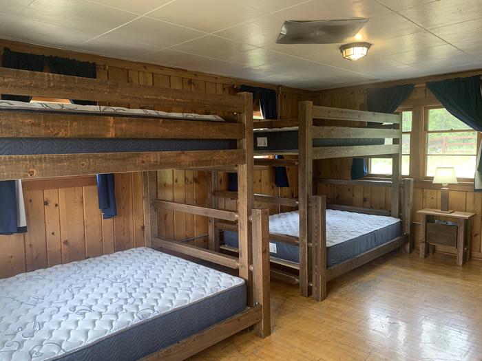 Historic forest service cabin bedroom with bunk beds.Star Meadow Guard Station bedroom interior with two bunk beds with queen and full mattresses, sleeps 6.