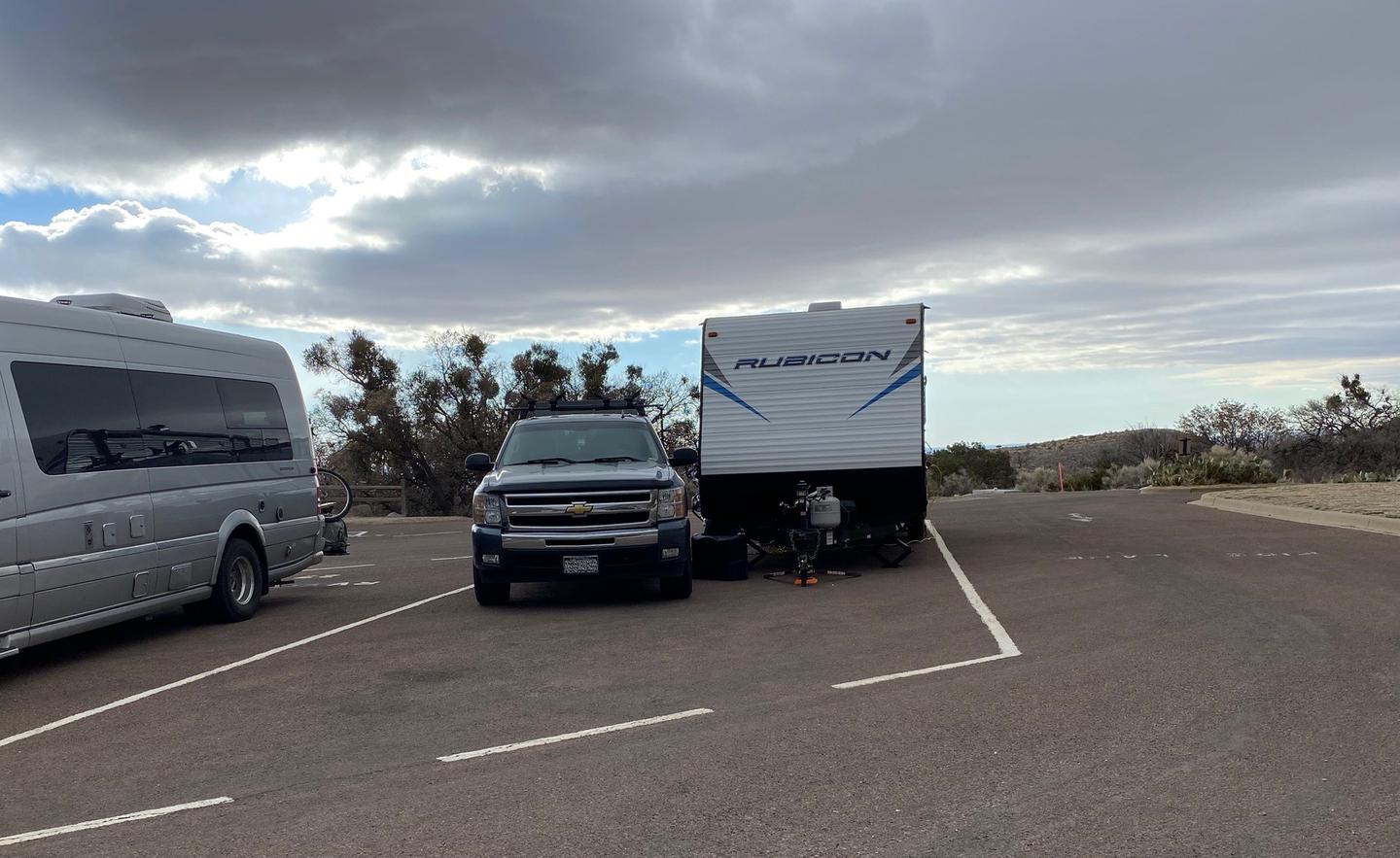 RV site 26 shown in this photo occupied by a camper trailer and truck.  Limited space is available on either side of site.RV site 26 while occupied with camper trailer and truck.