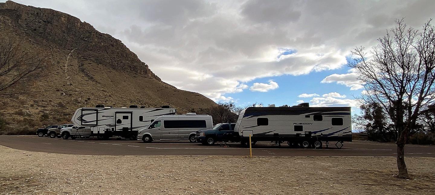 Row of RV campsites number 26-30.  The sites are occupied in this photo to help demonstrate the layout of the sites as a row of paved parking spaces.Row of RV campsites number 26-30.  Site 26 is the space nearest to the camera.