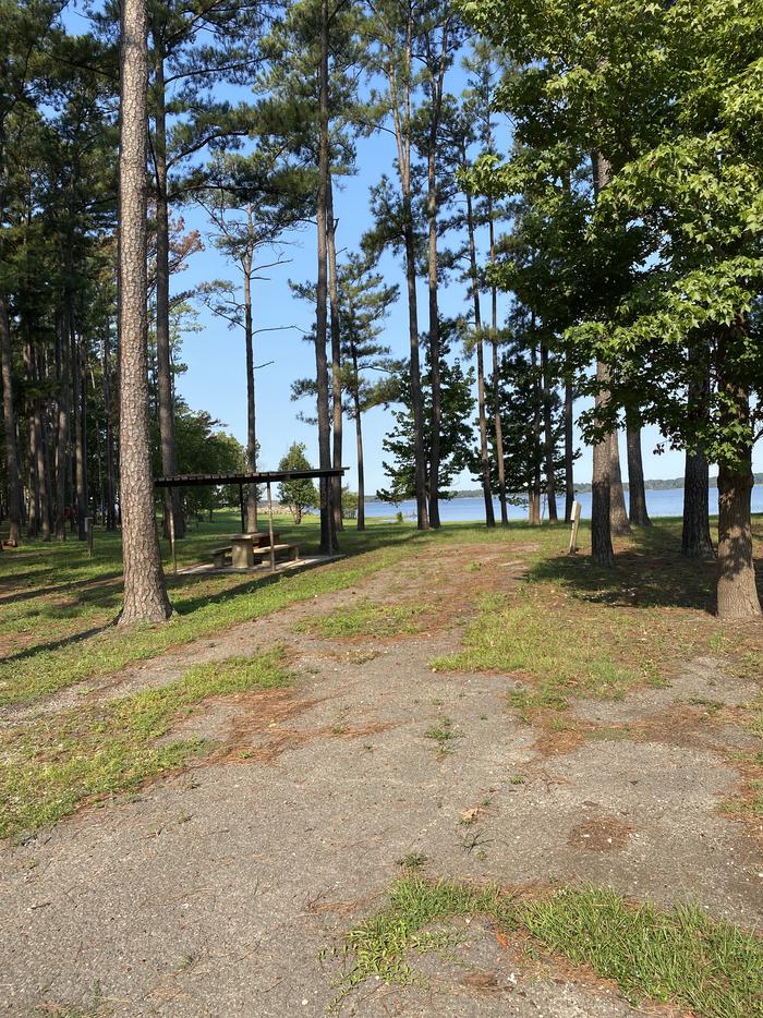 A photo of Site 059 of Loop B at MILL CREEK (TEXAS) with Picnic Table, Electricity Hookup, Fire Pit, Shade, Waterfront, Lantern Pole, Water Hookup, Lean To / Shelter