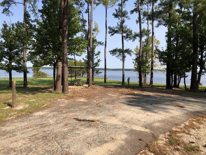 A photo of Site 062 of Loop B at MILL CREEK (TEXAS) with Picnic Table, Electricity Hookup, Fire Pit, Shade, Waterfront, Water Hookup