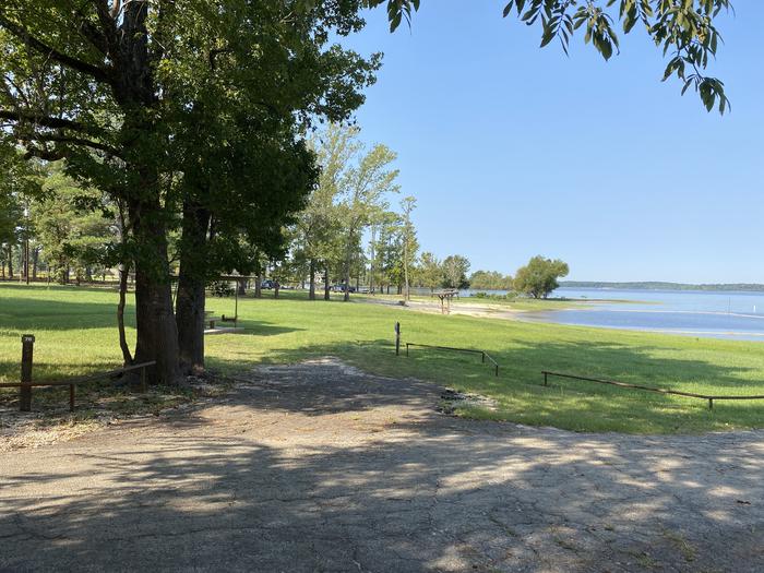 A photo of Site 076 of Loop C at MILL CREEK (TEXAS) with Picnic Table, Electricity Hookup, Fire Pit, Shade, Waterfront, Lantern Pole, Water Hookup, Lean To / Shelter