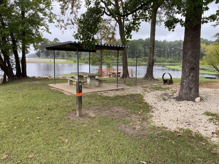 A photo of Site 28 of Loop LOOB at RAYBURN with Picnic Table, Electricity Hookup, Fire Pit, Shade, Waterfront, Lantern Pole, Water Hookup, Lean To / Shelter