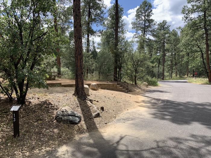 A photo of Site 13 of Loop C at LYNX CAMPGROUND showing curbside parking and 5 steps. 