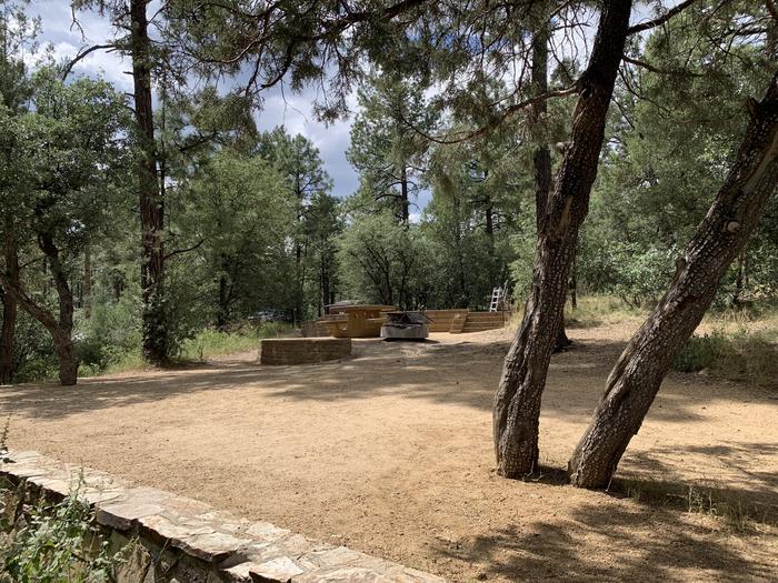 A photo of Site 12 of Loop C at LYNX CAMPGROUND with Picnic Table, Fire Pit. View is back toward campground to show lower tier. 