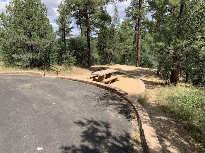 A photo of Site 12 of Loop C at LYNX CAMPGROUND with Picnic Table, Fire Pit with 5 steps down to two-tier campsite. Parallel curbside parking shown. 