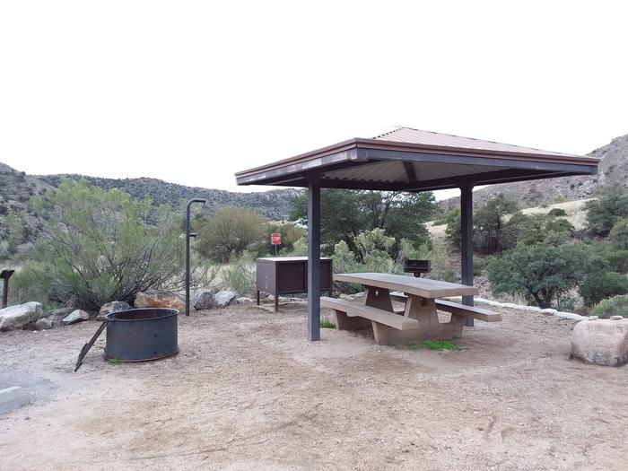 Site 12 with a picnic table, campfire ring, camp grill, lantern pole, food storage, and parking.