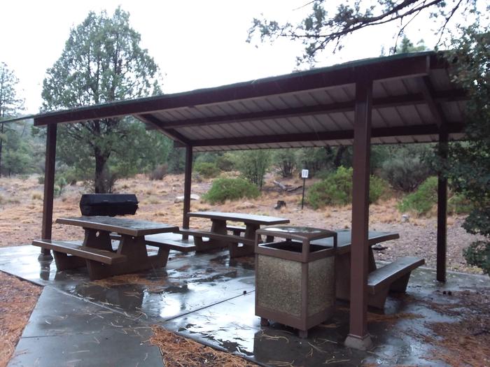 Thumb Butte Group Campsite B with picnic tables, a grill, and trash can all under a pavilion