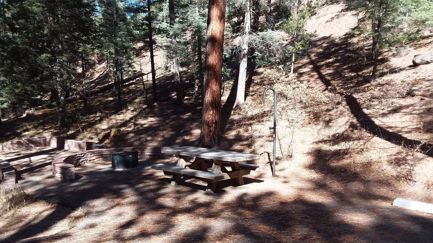 A view of a campsite with pines and restroom in the background.Black Canyon Campsites