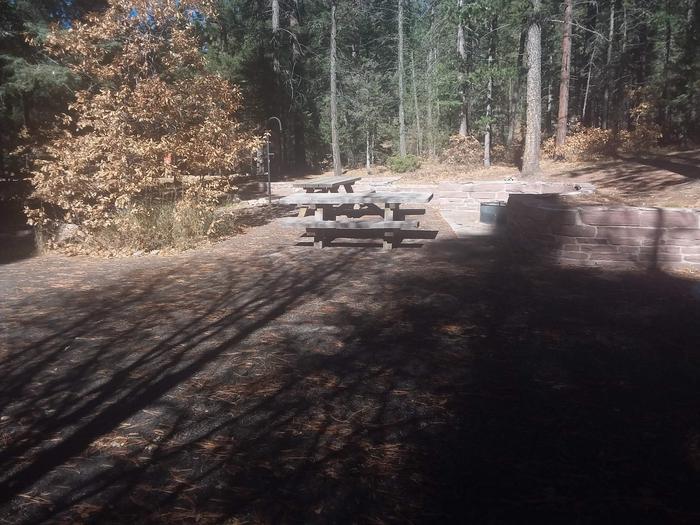 Site 26 with picnic tables, a campfire ring, lantern pole, and parking.