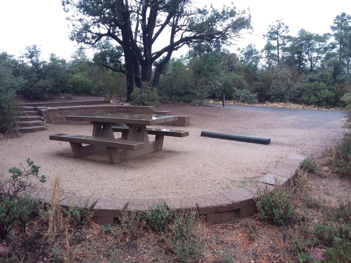 Yavapai Campsite 20 with a picnic table, fire ring and a designated space for tent placement behind the brick wall