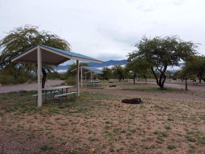 Campsite 168 with a picnic table under a metal ramada and a fire ring