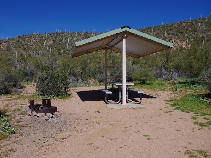 Campsite 7 at Burnt Corral Campground with a picnic table, fire ring, shade structure, and parking.